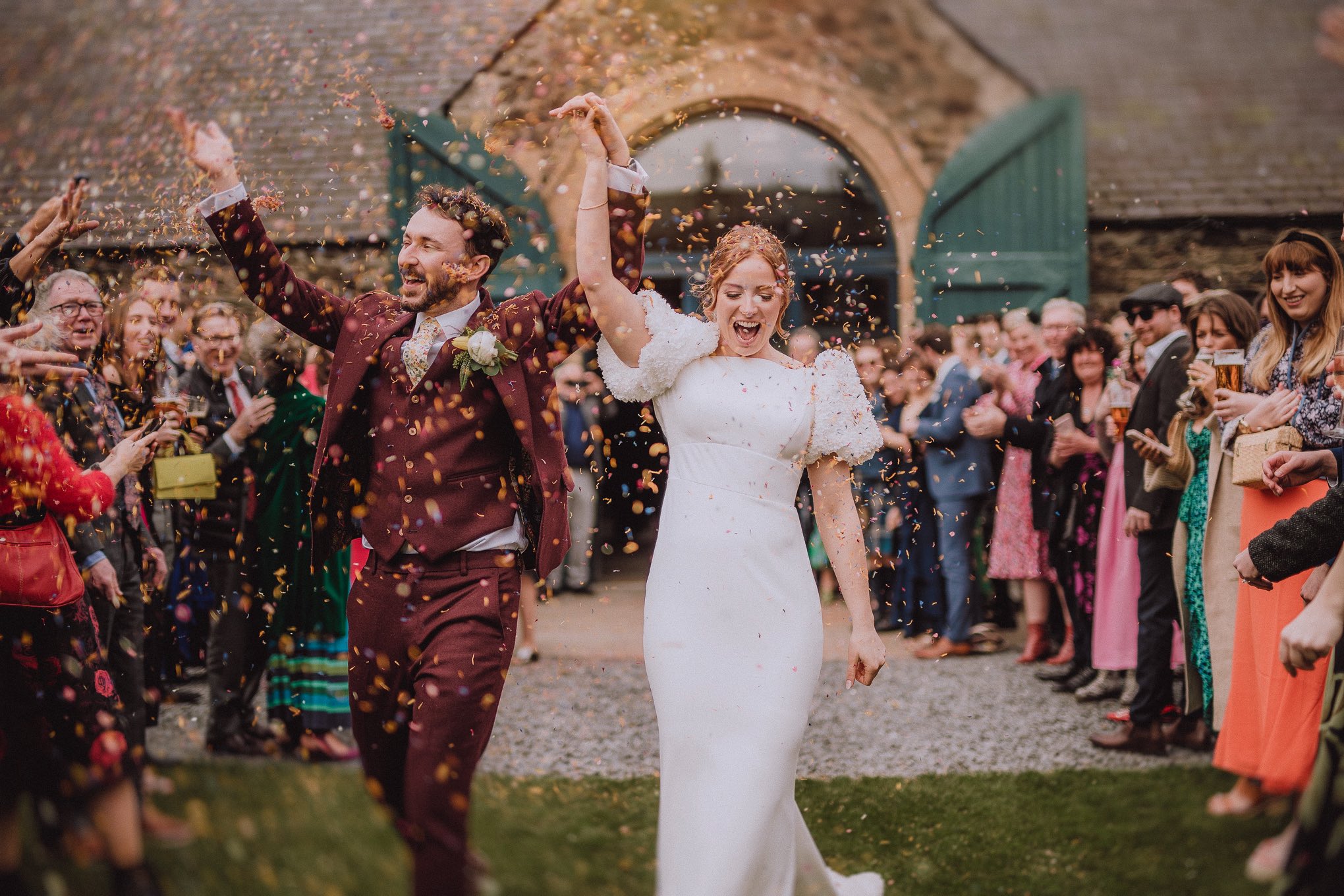 Beautiful Bride & Groom laughing as guests throw confetti at a barn relaxed natural wedding photography Scotland