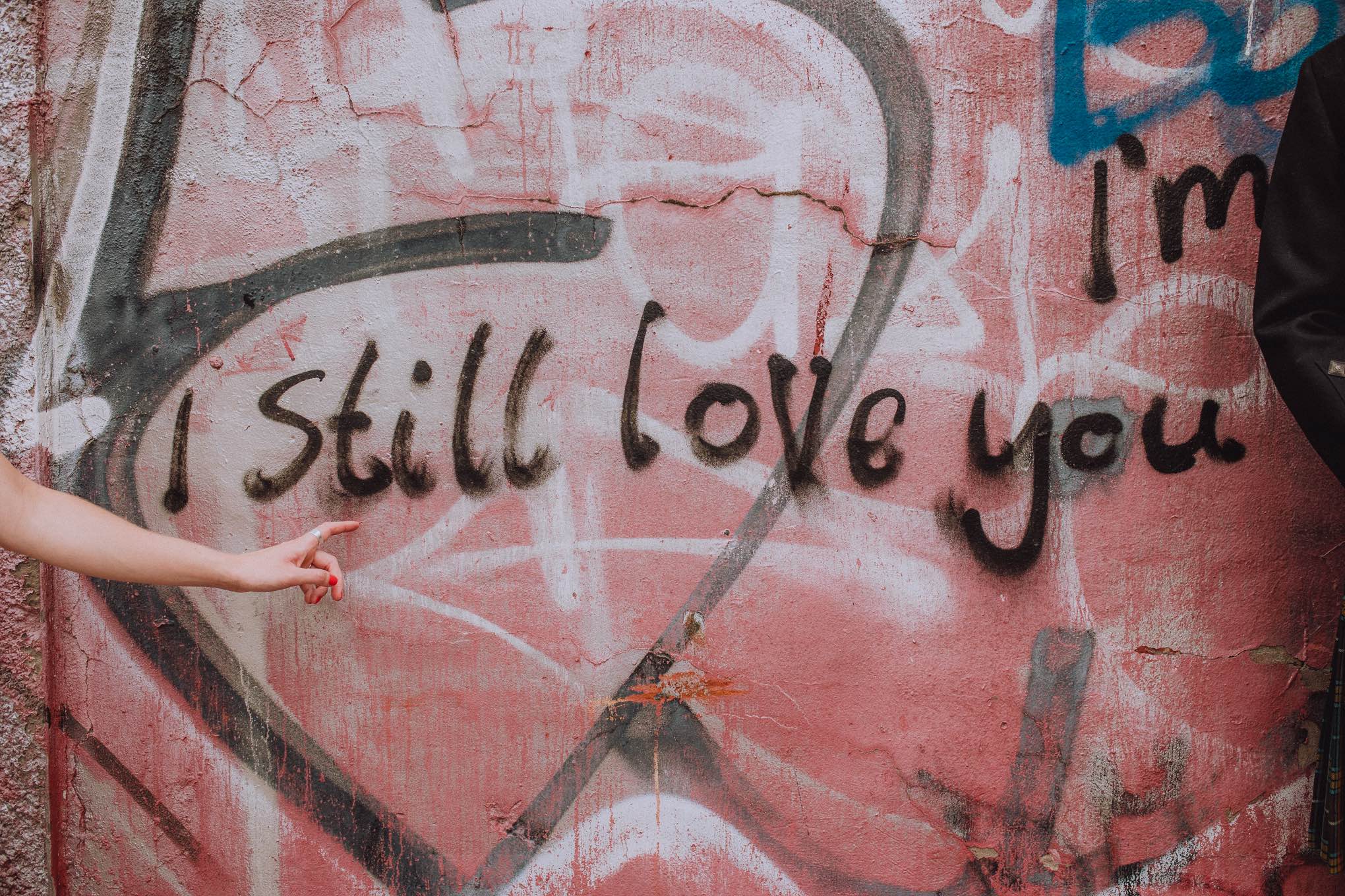 Urban wedding portrait with graffiti backdrop reading “I still love you,” photographed in a relaxed natural wedding photography Scotland approach