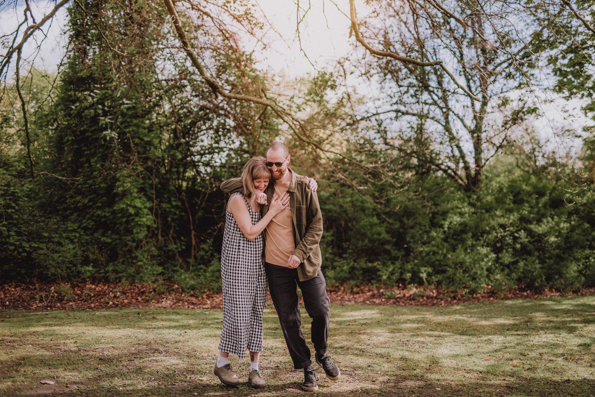 Wedding couple hugging and laughing mid-conversation outdoors, candid portrait captured with relaxed natural wedding photography Scotland