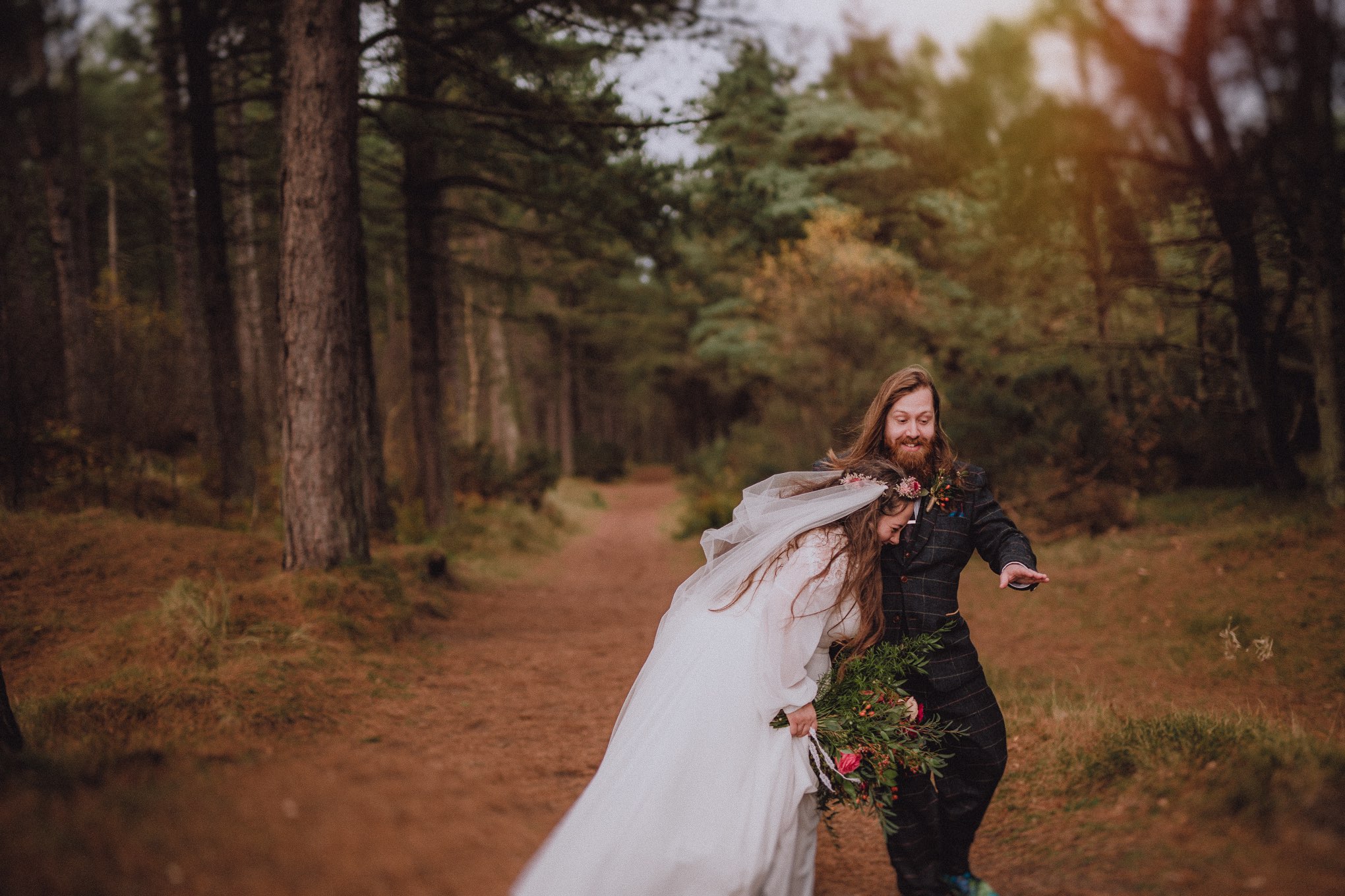 Bride and groom walking hand in hand through woodland just after their ceremony, smiling freely with natural movement and emotion, relax natural wedding photographer Glasgow Scotland