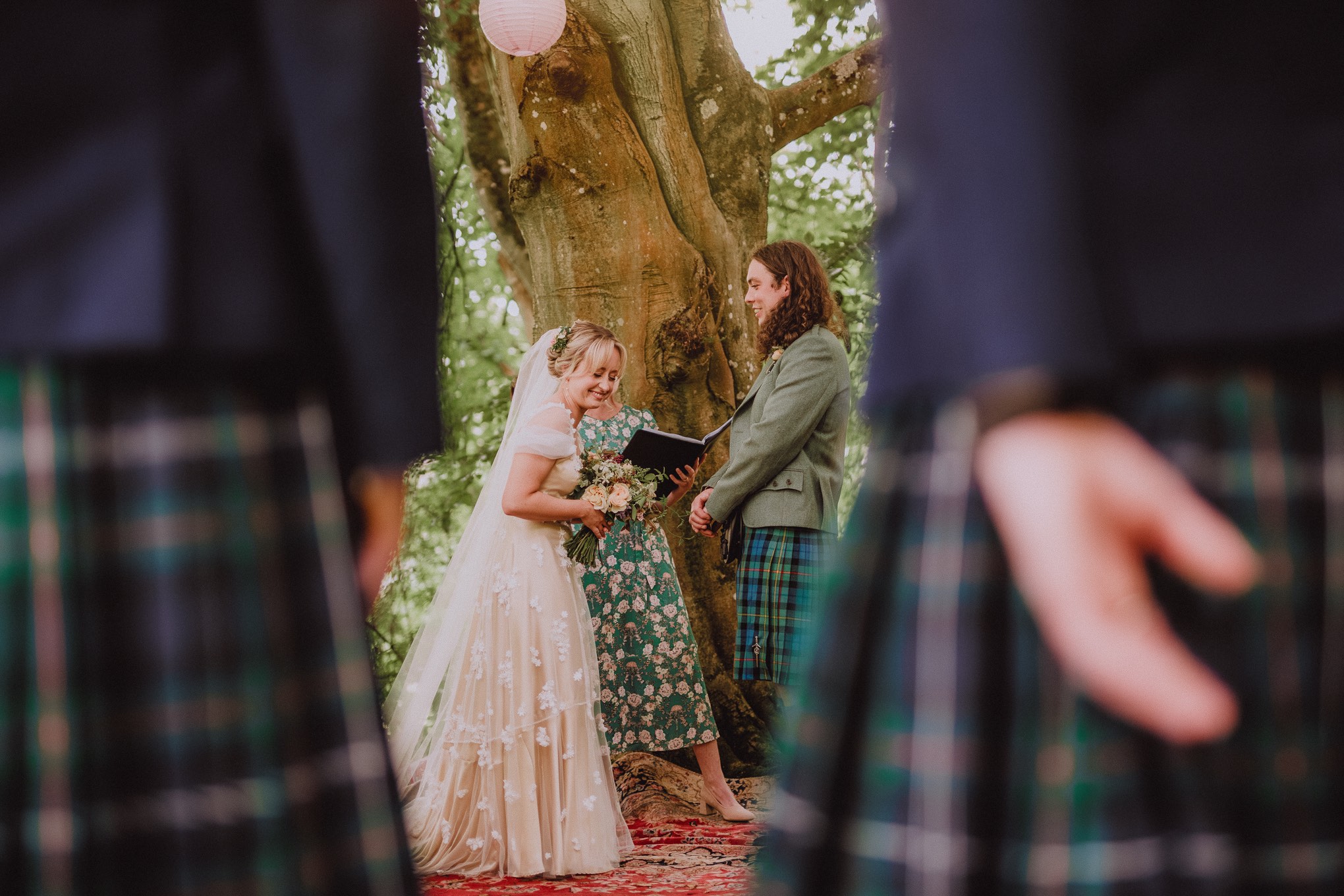 Outdoor woodland wedding ceremony with guests gathered closely, photographed in a relaxed natural wedding photography Scotland style