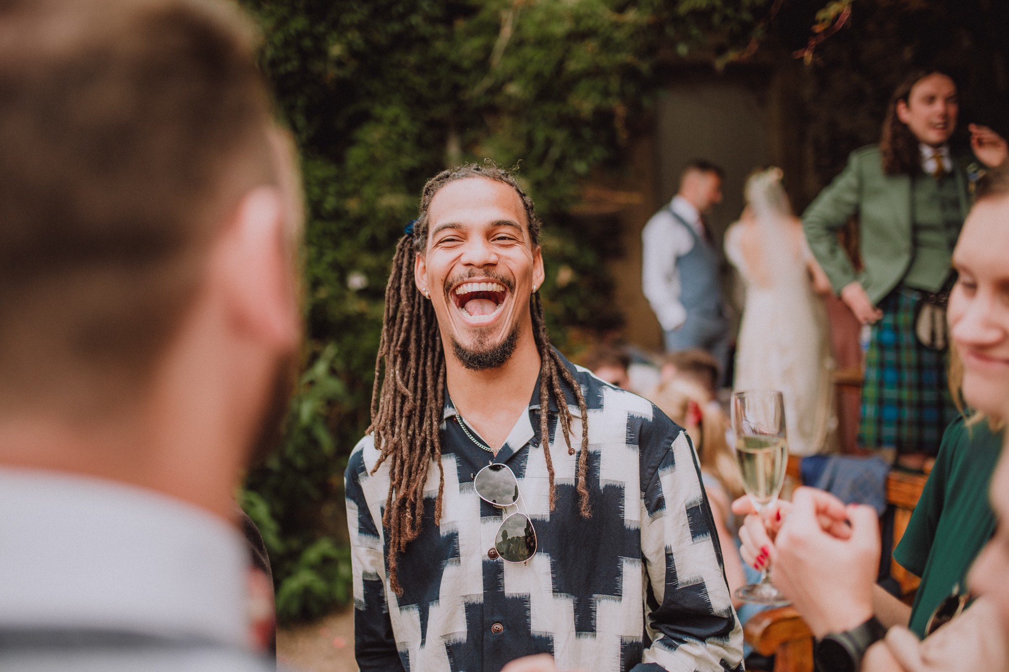 Close-up candid of wedding guest laughing during the outdoor wedding ceremony, with soft natural light, relax natural wedding photographer Glasgow Scotland